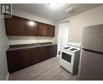 A kitchen with brown cabinets and a white stove.