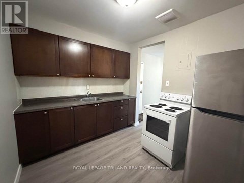 A kitchen with brown cabinets and a white stove.