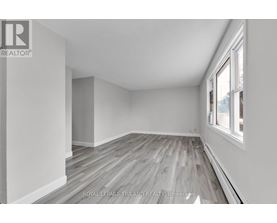 A room with wooden flooring and white walls.