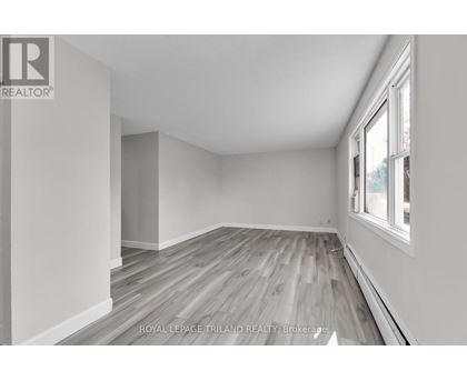A room with wooden flooring and white walls.