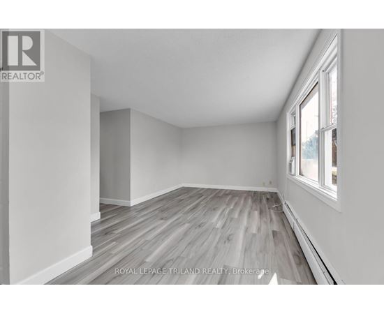 A room with wooden flooring and white walls.