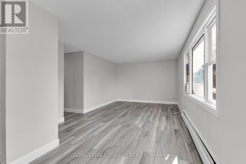 A room with wooden flooring and white walls.