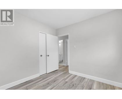 A white room with a door and a hallway.