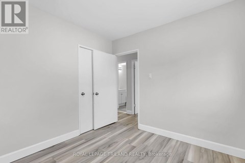 A white room with a door and a hallway.