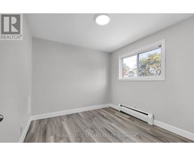 A room with a window and a radiator on the floor.