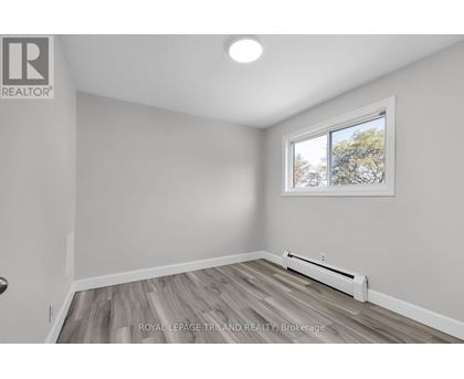 A room with a window and a radiator on the floor.