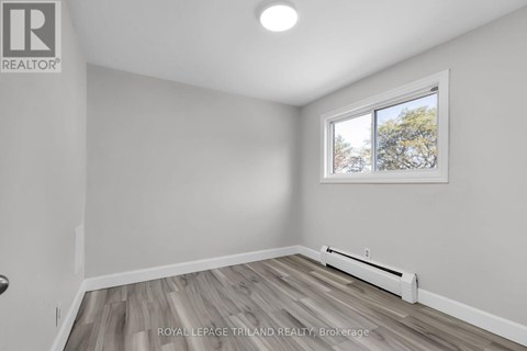 A room with a window and a radiator on the floor.