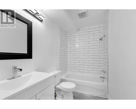 A white bathroom with a tub, sink and toilet.