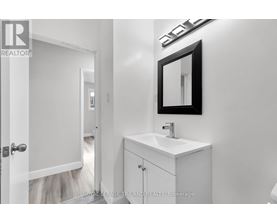 A white bathroom with a sink and mirror.