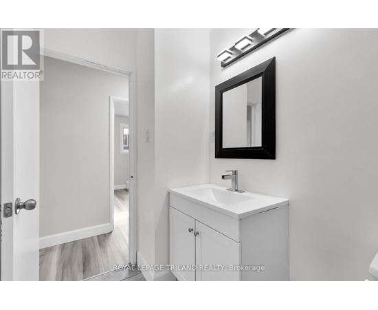 A white bathroom with a sink and mirror.