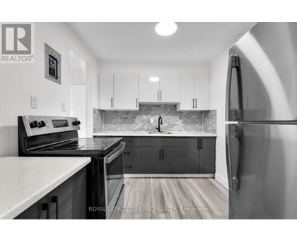 A kitchen with a refrigerator on the right side.