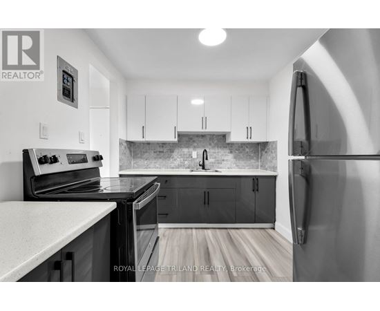 A kitchen with a refrigerator on the right side.