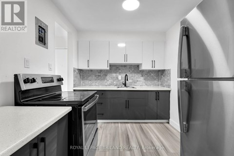 A kitchen with a refrigerator on the right side.