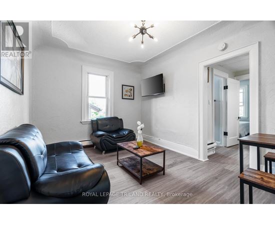 A living room with a black leather chair and a wooden coffee table.
