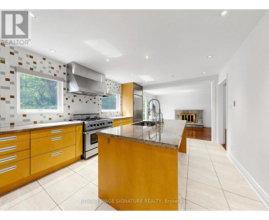 A modern kitchen with wooden cabinets and a marble island.
