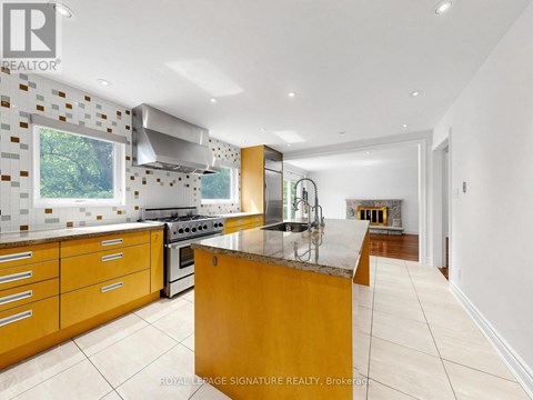 A modern kitchen with wooden cabinets and a marble island.
