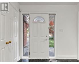 A white door with a glass window is in the middle of a white wall.