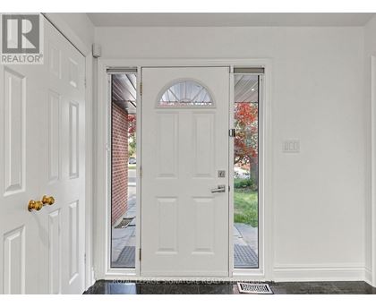 A white door with a glass window is in the middle of a white wall.
