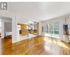 A spacious room with wooden floors and a large window.