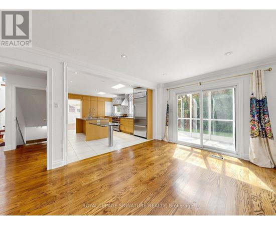 A spacious room with wooden floors and a large window.