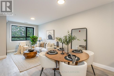 A well-lit dining room with a round table set for six.
