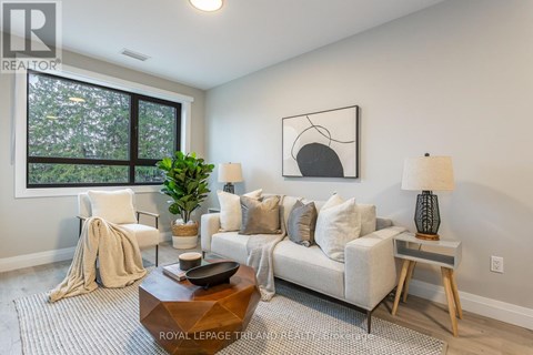 A living room with a white couch, a coffee table, and a large window.