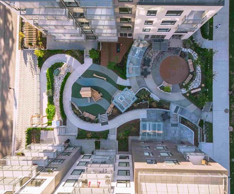 A modern building with a circular courtyard surrounded by greenery.