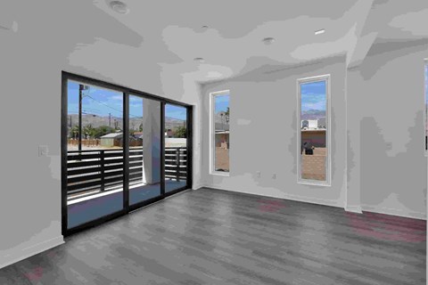 A room with a sliding glass door and a view of a parking lot.