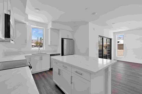 A kitchen with white cabinets and a large island.