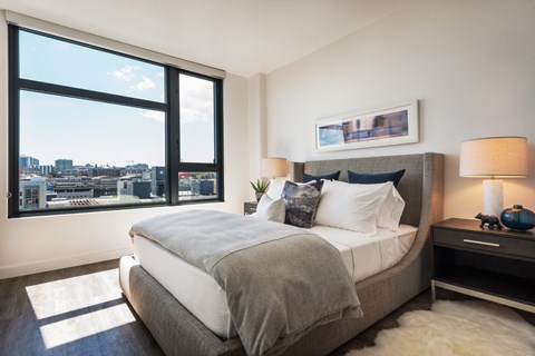 Bedroom with large windows and city views at 923 Folsom Apartments, California