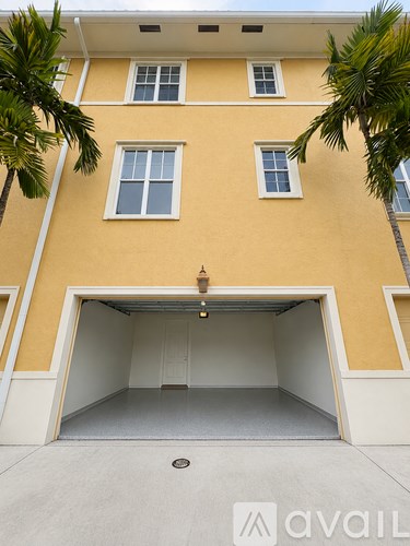A garage door is open in front of a yellow building.