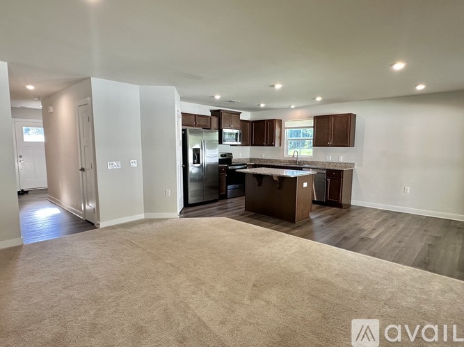 A spacious kitchen with a refrigerator, sink, and cabinets is available for rent.