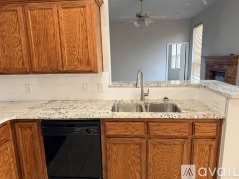 A kitchen with wooden cabinets and a granite countertop.