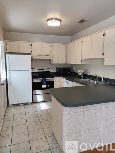 A kitchen with white cabinets and a white refrigerator.