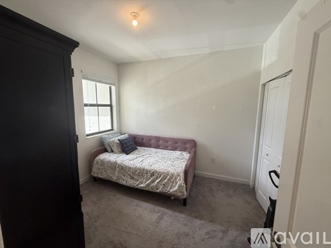 A bedroom with a bed and a window.