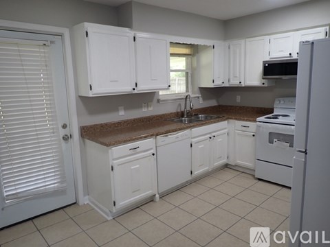 A kitchen with white cabinets and appliances.