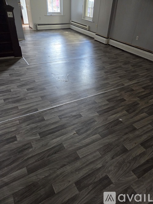 A room with a wooden floor and a white wall.