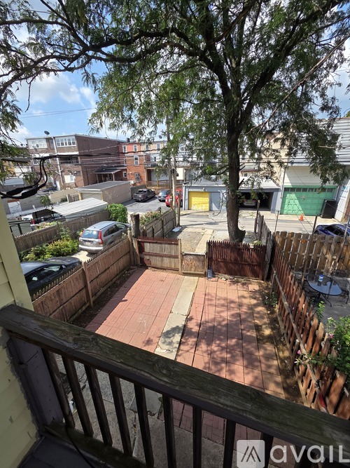 A backyard with a fence and a tree.