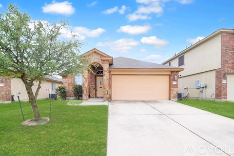 A house with a brown garage door and a tree in front.