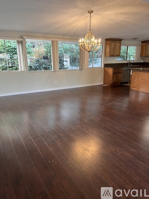 A large open room with wooden floors and a chandelier.