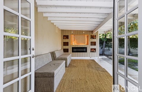 A living room with a grey couch and a wooden floor.
