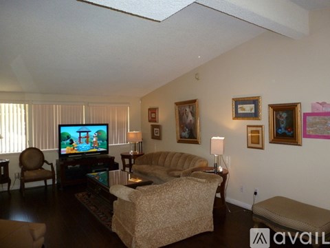 A living room with a couch, chair, and television.