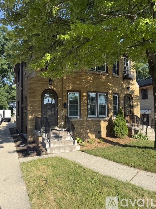 A house with a front porch and a tree in front.