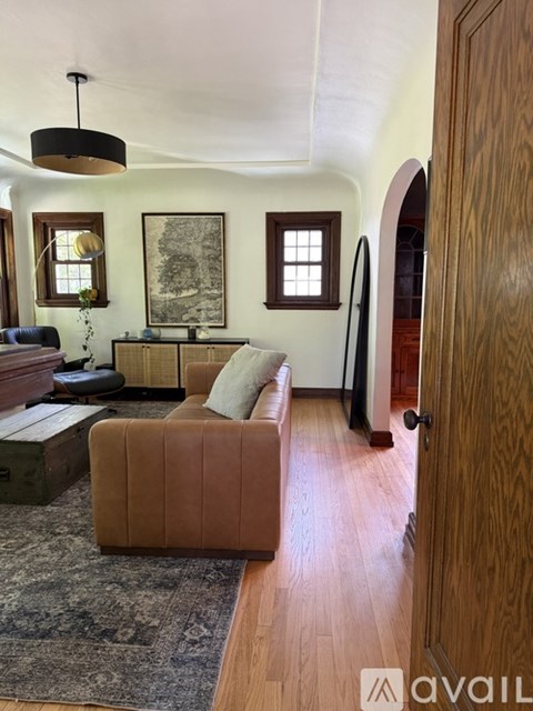 A living room with a brown couch and a rug.