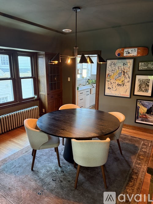 A dining room with a round table and chairs.