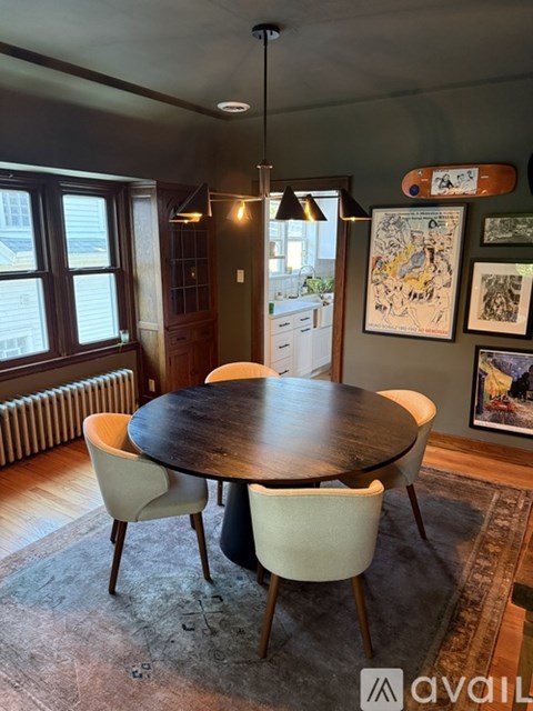 A dining room with a round table and chairs.