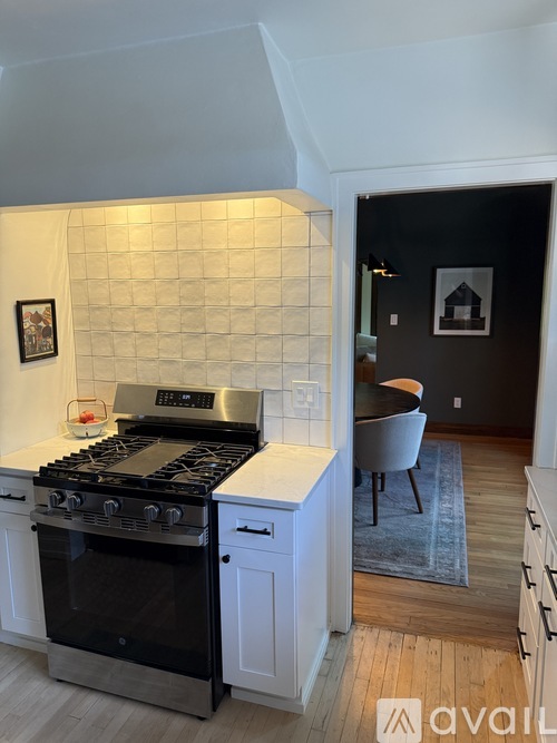A kitchen with a black stove top oven and a white backsplash.