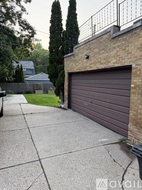 A garage door is closed and the wall is brown.