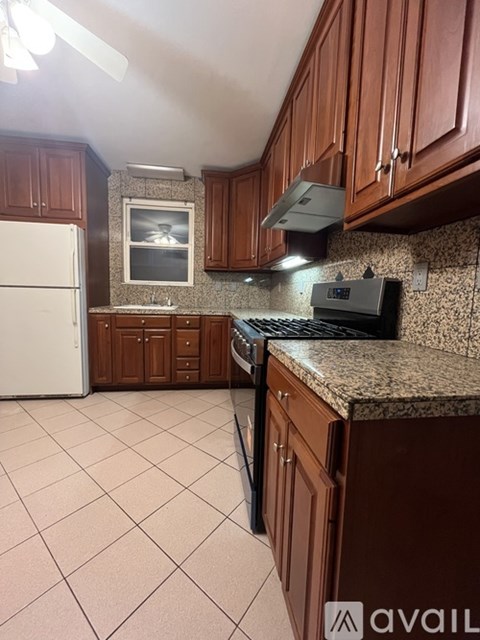 A kitchen with brown cabinets and a white refrigerator.