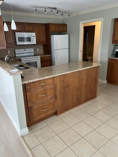 A kitchen with a white refrigerator and wooden cabinets.
